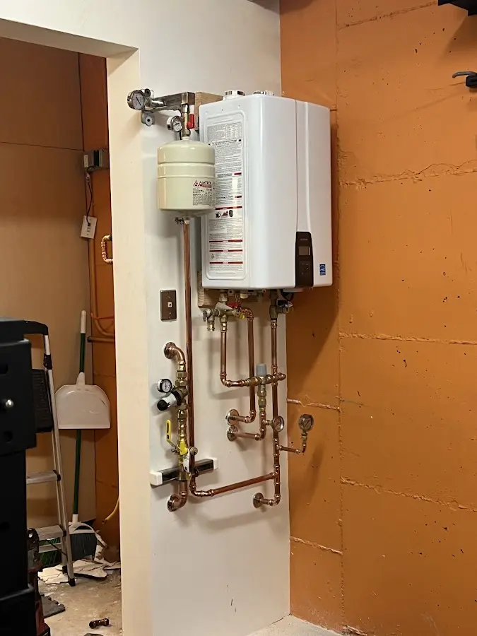 Plumbing technician inspecting water heater connections in Bulverde
